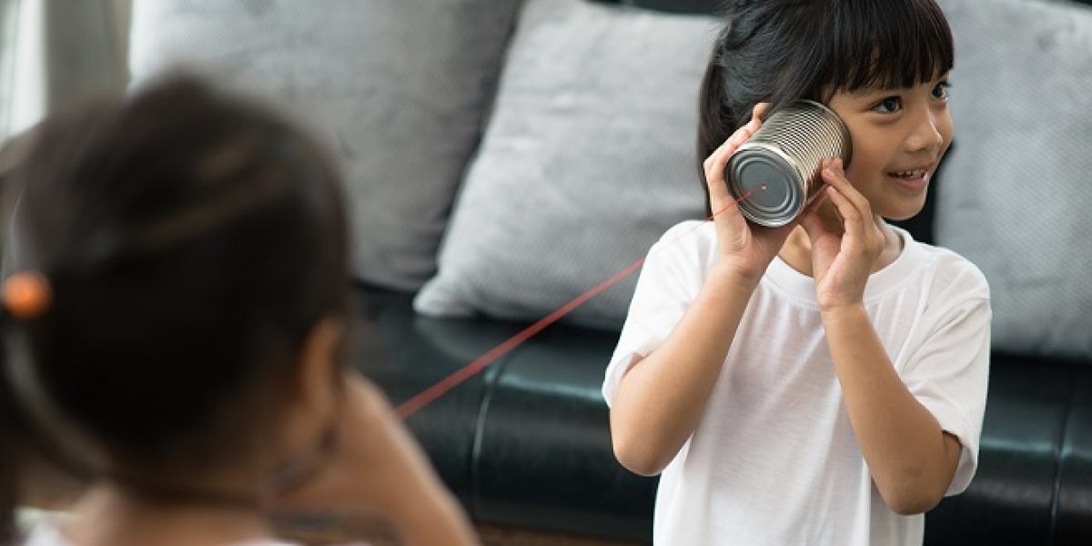 kids playing with tin can and string phone as communication concept